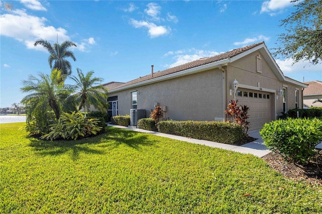 single story home with cooling unit, a garage, and a front yard