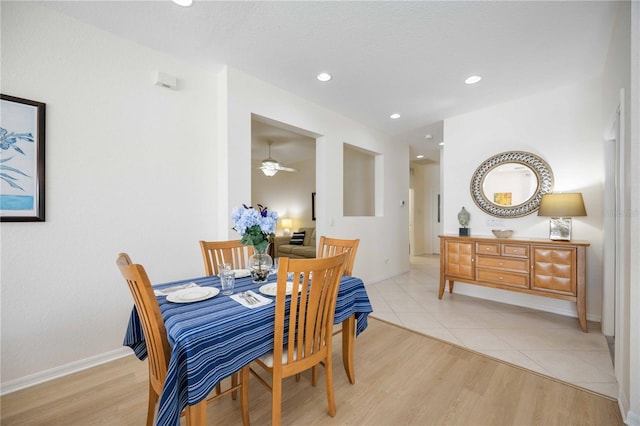 dining space with ceiling fan and light hardwood / wood-style flooring