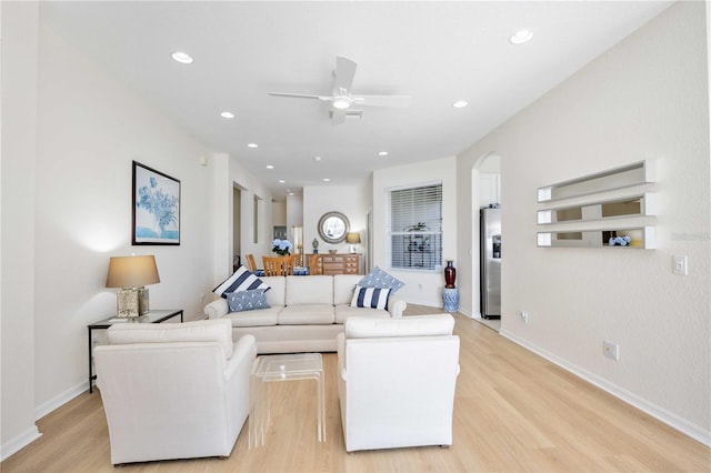 living room featuring ceiling fan and light hardwood / wood-style flooring