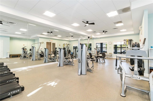 gym with a paneled ceiling and ceiling fan