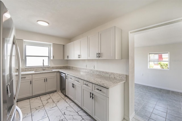 kitchen featuring light stone countertops, sink, and appliances with stainless steel finishes