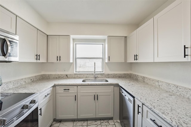 kitchen with white cabinetry, light stone countertops, sink, and appliances with stainless steel finishes