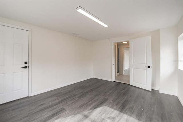 empty room with dark wood-type flooring