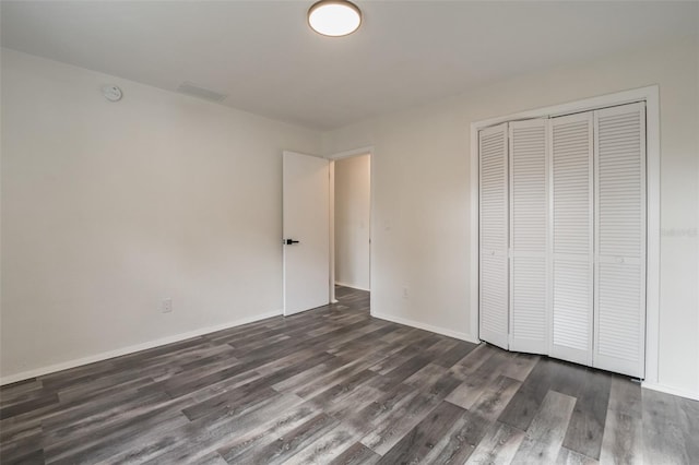 unfurnished bedroom featuring dark hardwood / wood-style flooring and a closet