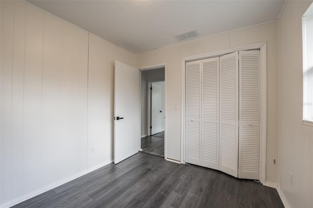 unfurnished bedroom with a closet and dark hardwood / wood-style floors