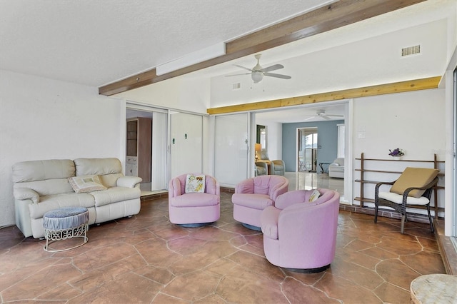 living room with ceiling fan, a textured ceiling, and beam ceiling