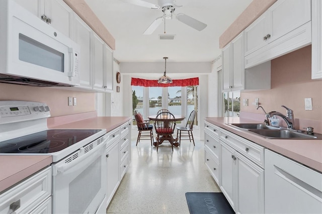 kitchen featuring sink, white cabinets, hanging light fixtures, ceiling fan, and white appliances