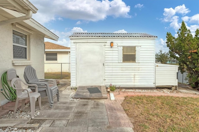 back of property featuring a storage shed and a patio area