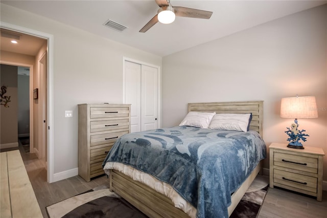 bedroom featuring ceiling fan, light hardwood / wood-style floors, and a closet