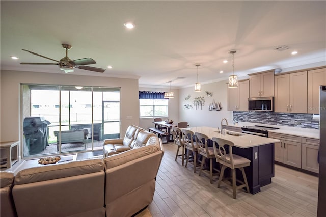 living room featuring crown molding, sink, ceiling fan, and light hardwood / wood-style flooring