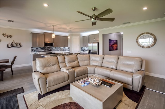 living room with ornamental molding and light hardwood / wood-style floors