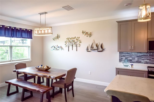 dining space featuring ornamental molding and wood-type flooring