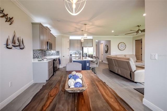 dining room with ceiling fan, ornamental molding, and hardwood / wood-style floors