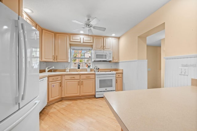 kitchen featuring white appliances, sink, light hardwood / wood-style flooring, ceiling fan, and light brown cabinetry