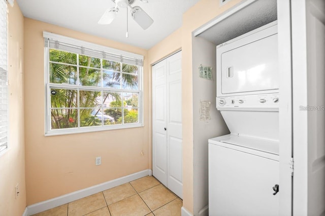 laundry room with ceiling fan, light tile patterned floors, and stacked washing maching and dryer