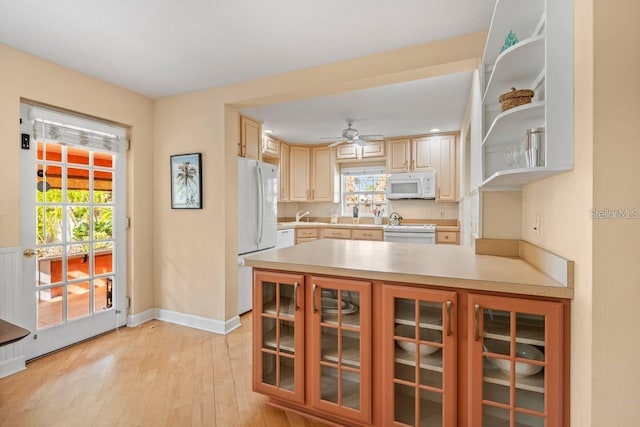 kitchen with kitchen peninsula, white appliances, ceiling fan, light brown cabinets, and light hardwood / wood-style floors