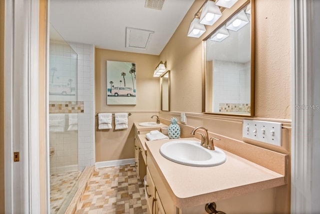 bathroom with a tile shower and vanity