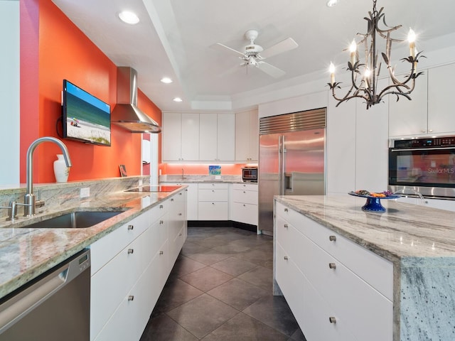 kitchen with white cabinets, wall chimney exhaust hood, sink, and stainless steel appliances