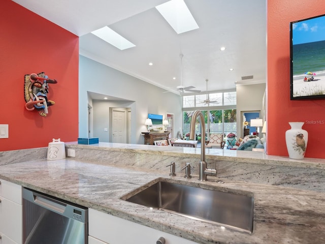 kitchen with a skylight, stainless steel dishwasher, crown molding, sink, and white cabinetry