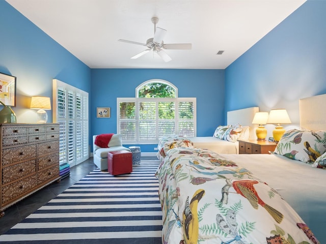 bedroom with ceiling fan and dark tile patterned floors