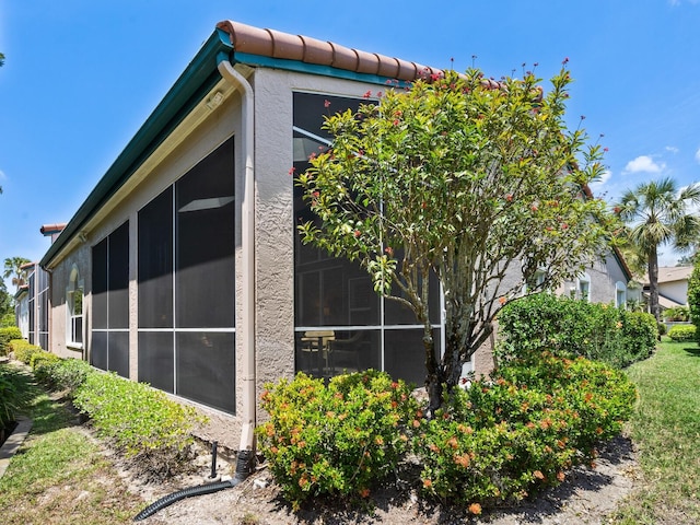 view of property exterior featuring a sunroom