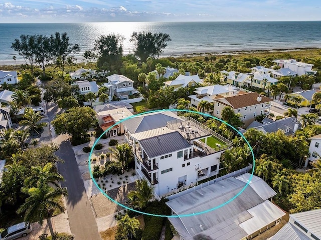 birds eye view of property with a water view and a beach view