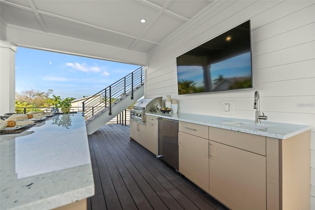 wooden terrace with a grill, sink, and an outdoor kitchen