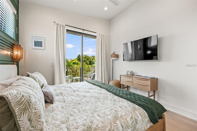 bedroom with access to exterior, hardwood / wood-style floors, and vaulted ceiling