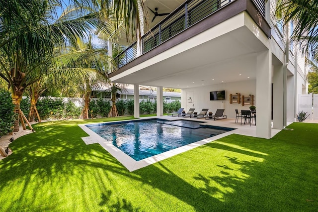 view of pool with a patio area and a yard