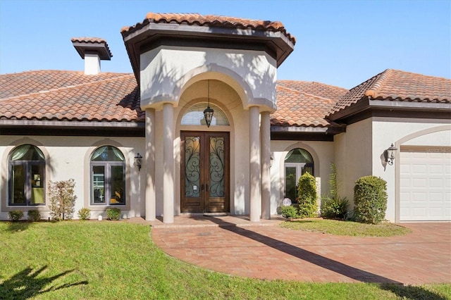 view of front of property with a front yard, french doors, and a garage