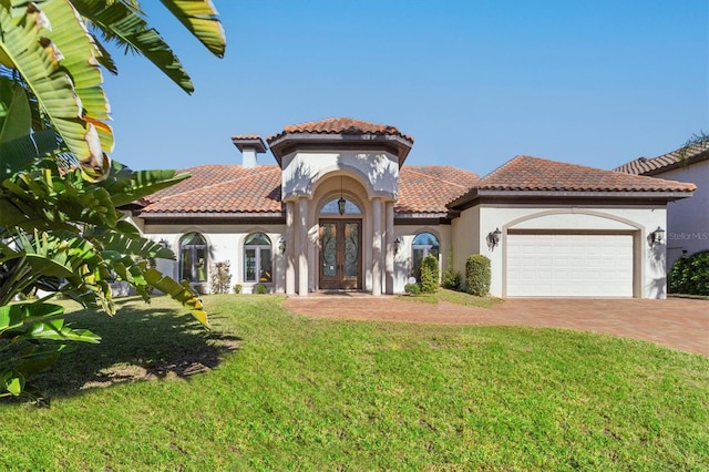 mediterranean / spanish-style home with french doors, a front yard, and a garage