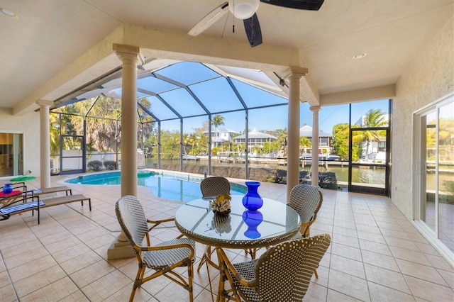 sunroom / solarium featuring ceiling fan, a water view, and a swimming pool