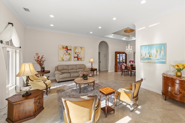 tiled living room featuring a notable chandelier, ornamental molding, and a tray ceiling