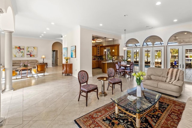 living room with ornate columns, ornamental molding, light tile patterned floors, and french doors