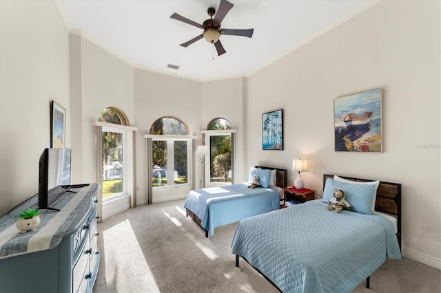 bedroom featuring ceiling fan, a towering ceiling, light carpet, and ornamental molding