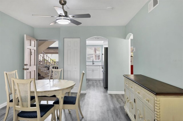 dining area featuring hardwood / wood-style floors, ceiling fan, and sink