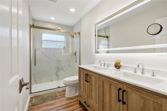 bathroom with toilet, a shower with door, vanity, and hardwood / wood-style flooring