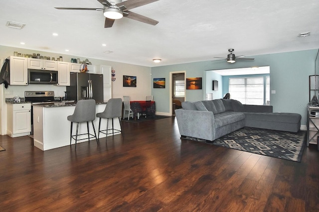 living room featuring dark hardwood / wood-style floors and ceiling fan