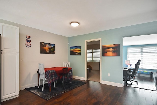 dining space with a wealth of natural light and dark wood-type flooring