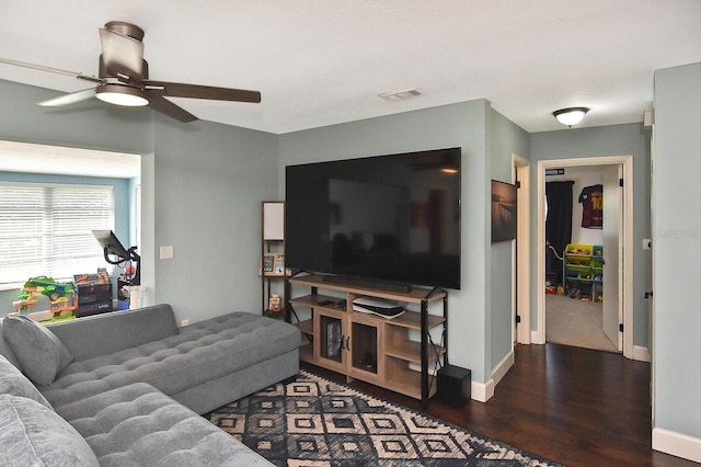 living room featuring ceiling fan and dark hardwood / wood-style floors