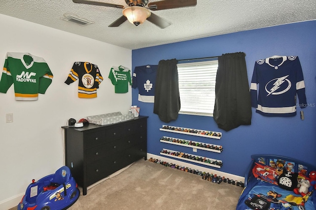 carpeted bedroom featuring ceiling fan and a textured ceiling