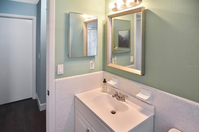 bathroom featuring vanity and tile walls