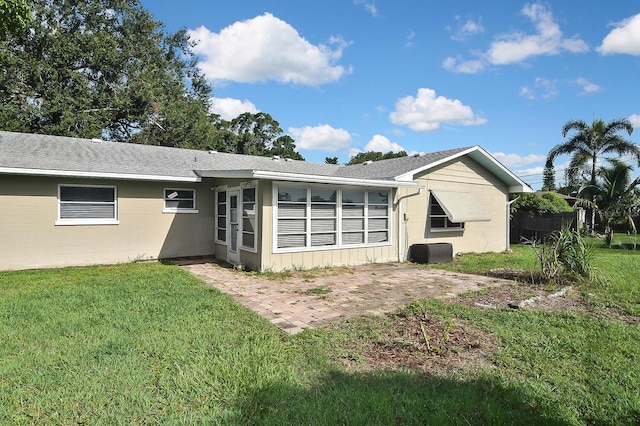 rear view of house featuring a lawn