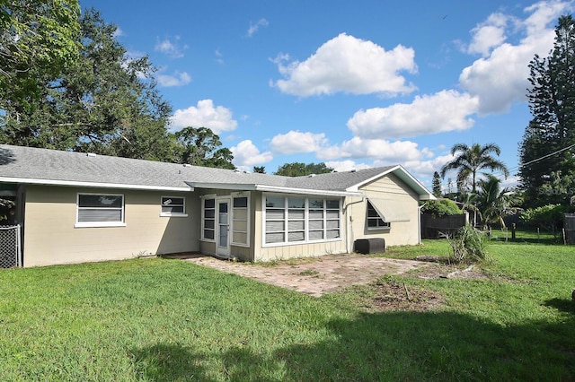 rear view of property featuring a patio area and a lawn