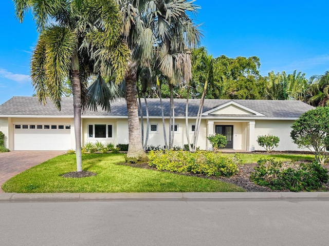 ranch-style home featuring a front yard and a garage