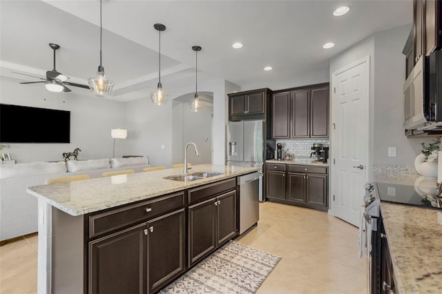 kitchen with ceiling fan, sink, pendant lighting, a kitchen island with sink, and appliances with stainless steel finishes