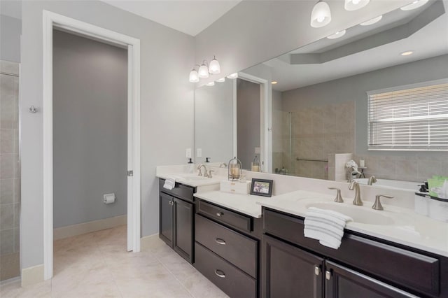 bathroom featuring tiled shower, vanity, and tile patterned floors