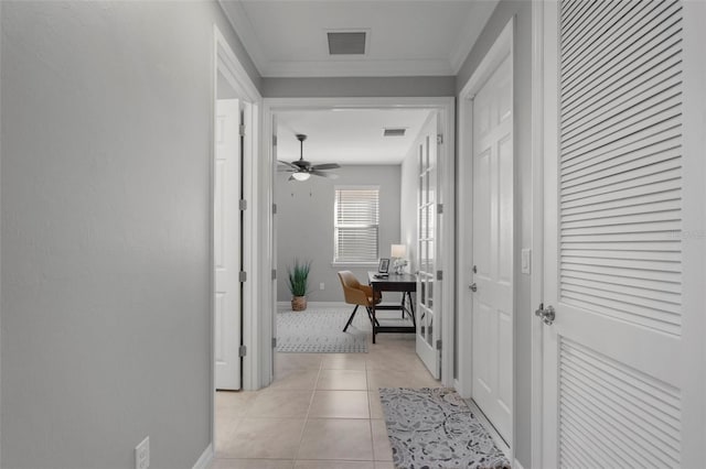 corridor featuring light tile patterned floors and ornamental molding