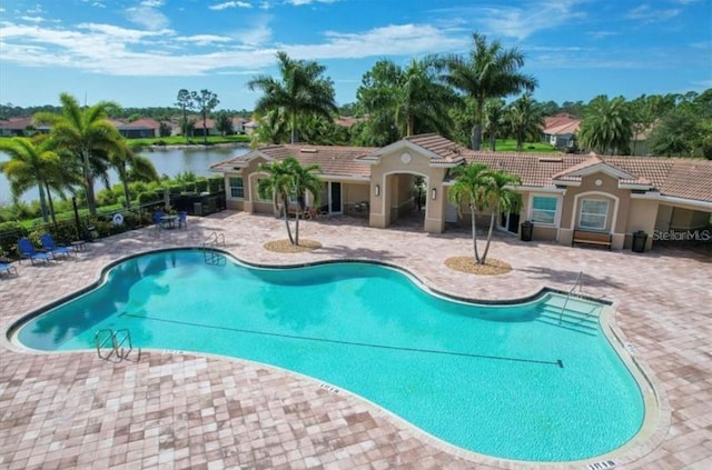 view of swimming pool with a patio area and a water view