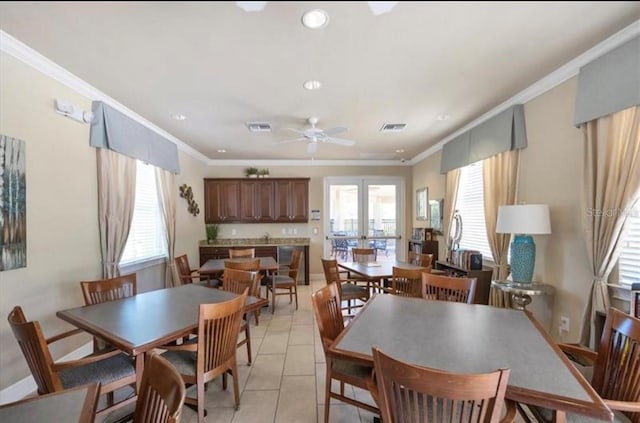 dining space featuring ceiling fan, plenty of natural light, crown molding, and light tile patterned flooring